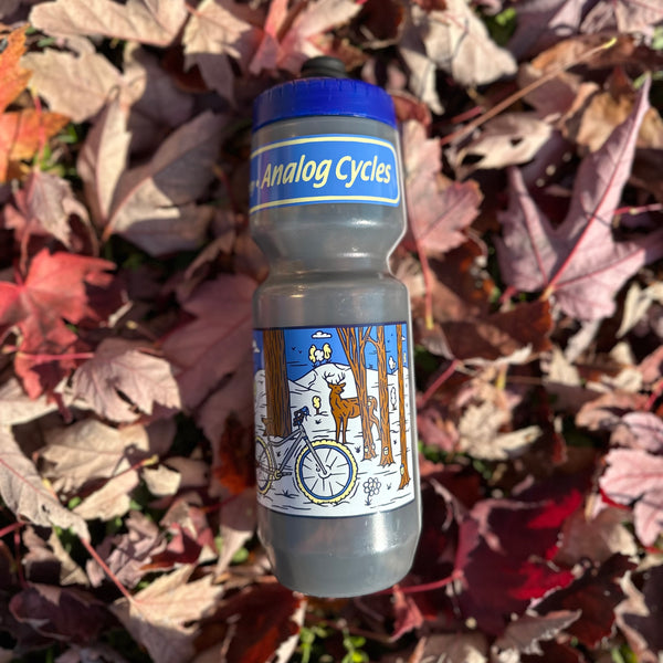 a blue and grey water bottle with Analog Cycles printed on top and  a wintery sugaring scene on the bottom 