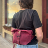 Person wearing a maroon backpack outdoors